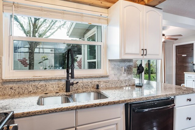 kitchen featuring light stone counters, white cabinetry, a sink, dishwasher, and tasteful backsplash