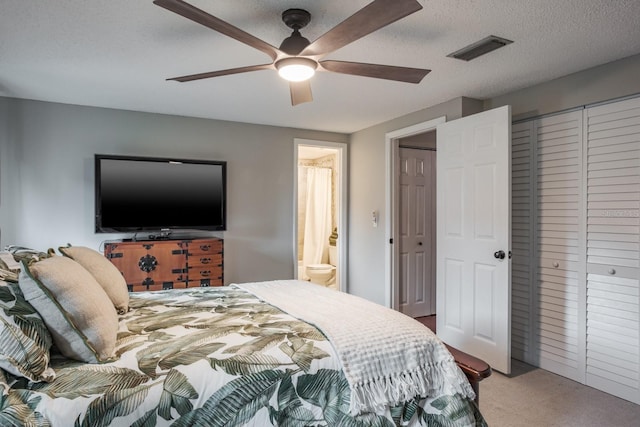 carpeted bedroom with connected bathroom, visible vents, a textured ceiling, and ceiling fan