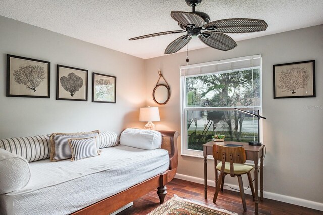 interior space with baseboards, a textured ceiling, and wood finished floors