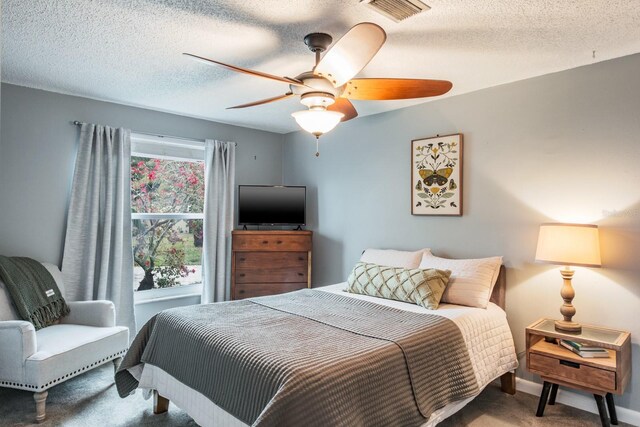 carpeted bedroom featuring baseboards, visible vents, a textured ceiling, and ceiling fan