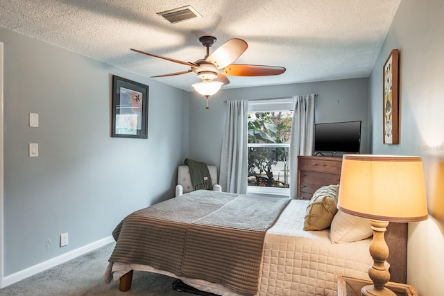 bedroom featuring a ceiling fan, carpet, visible vents, baseboards, and a textured ceiling