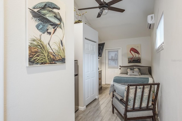 bedroom featuring wood finish floors, lofted ceiling, a ceiling fan, and a wall mounted AC