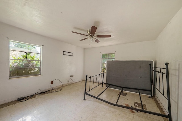 bedroom with tile patterned floors, multiple windows, and ceiling fan