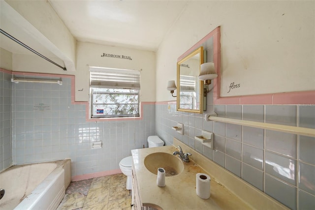 full bathroom with tile walls, wainscoting, toilet, and vanity