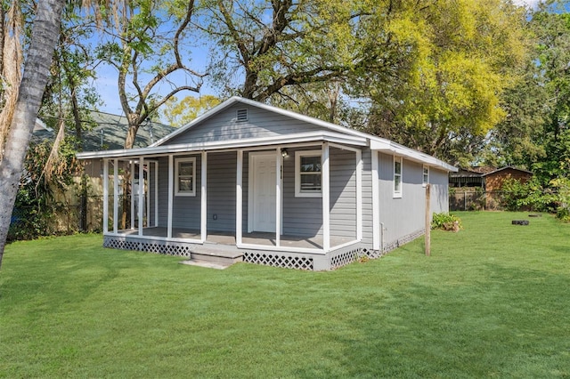 back of house featuring a porch, a lawn, and fence