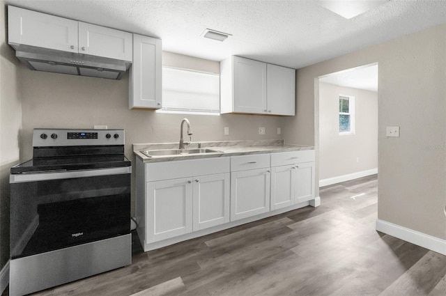 kitchen with visible vents, electric range, a sink, white cabinets, and under cabinet range hood