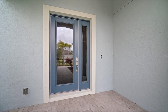 entrance to property with stucco siding