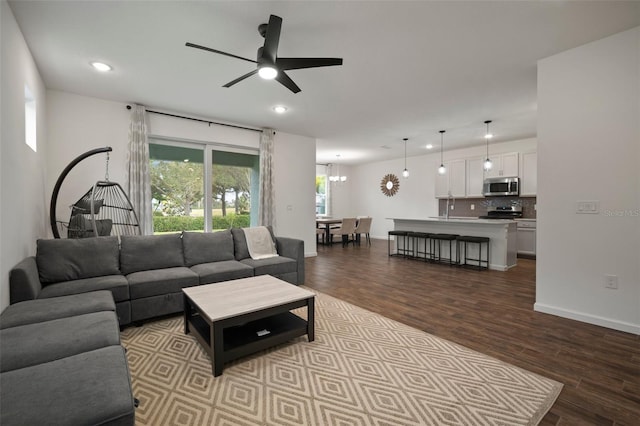 living area featuring recessed lighting, baseboards, wood finished floors, and ceiling fan with notable chandelier