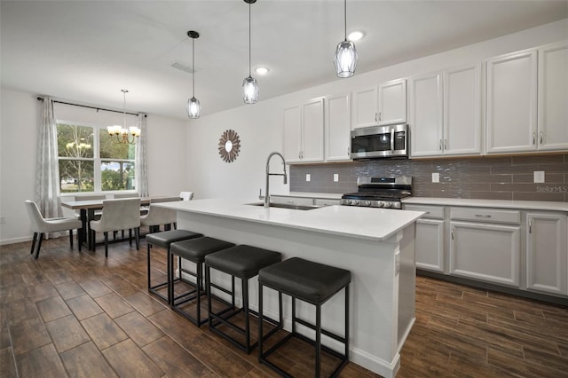 kitchen with tasteful backsplash, visible vents, wood tiled floor, appliances with stainless steel finishes, and a sink