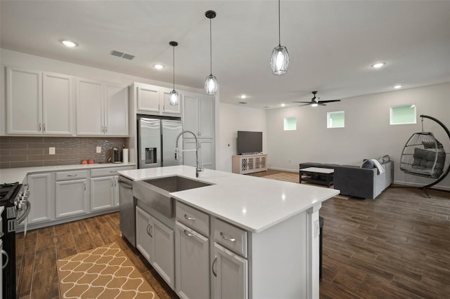 kitchen featuring a sink, light countertops, open floor plan, and stainless steel appliances