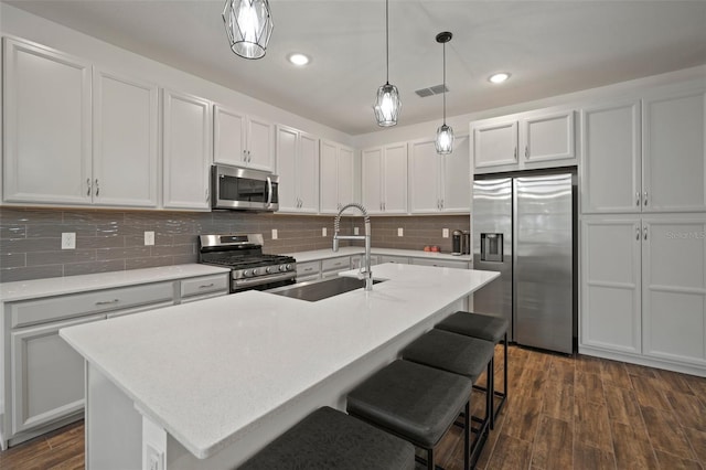 kitchen featuring a sink, visible vents, appliances with stainless steel finishes, and dark wood finished floors