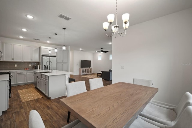 dining room featuring dark wood finished floors, visible vents, recessed lighting, and ceiling fan with notable chandelier