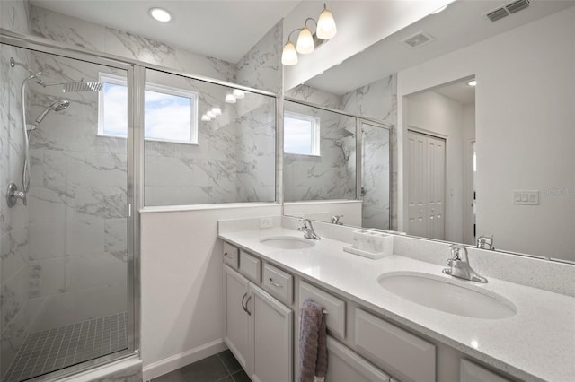 bathroom featuring a sink, visible vents, a marble finish shower, and double vanity