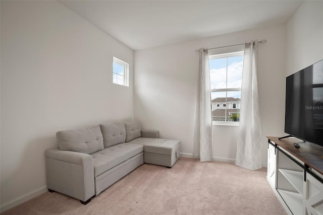 living area featuring light colored carpet and baseboards