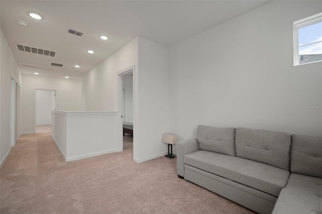 living room featuring recessed lighting, visible vents, baseboards, and light colored carpet