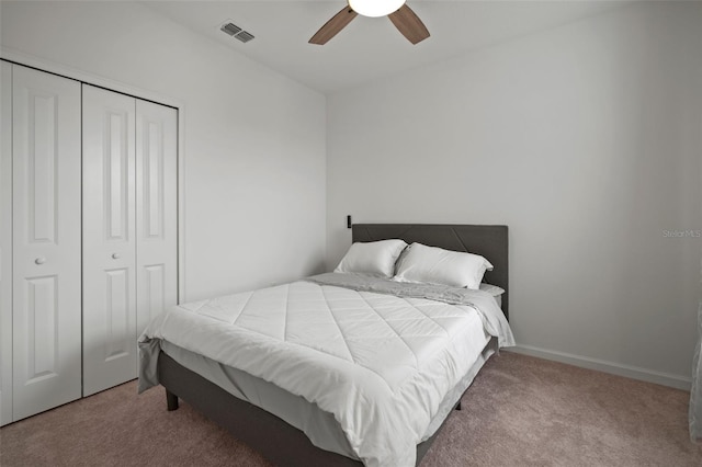 bedroom featuring visible vents, a closet, carpet, baseboards, and ceiling fan