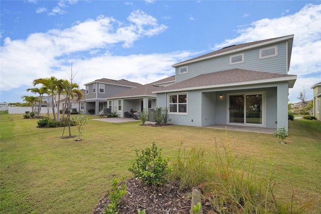 back of property featuring a patio, a lawn, roof with shingles, and stucco siding