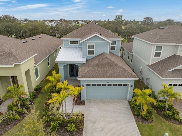 view of front of home with a garage, decorative driveway, stucco siding, and a shingled roof