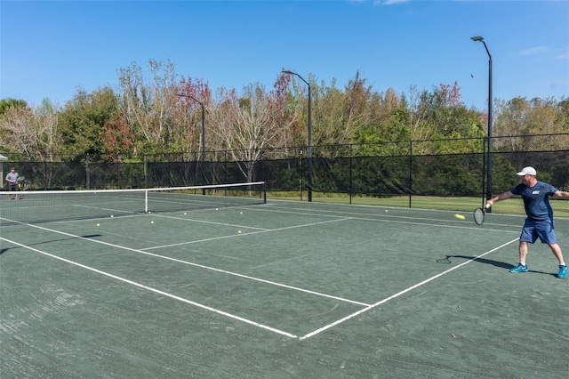 view of tennis court with fence