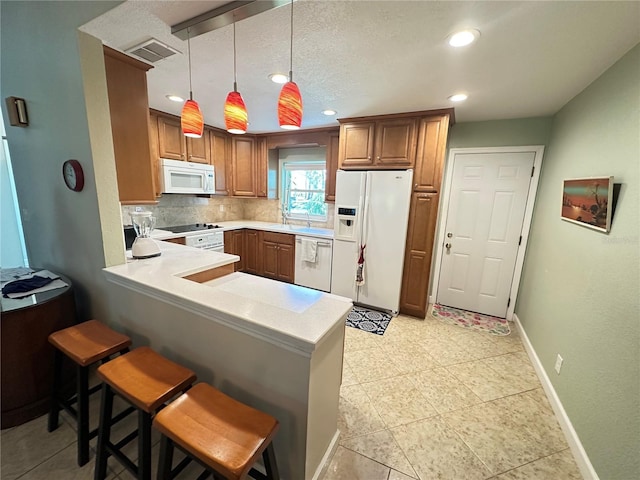 kitchen with backsplash, white appliances, a peninsula, light countertops, and baseboards