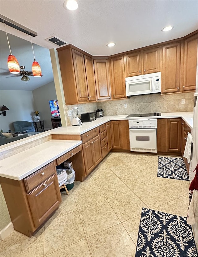 kitchen with white appliances, tasteful backsplash, light countertops, and brown cabinets