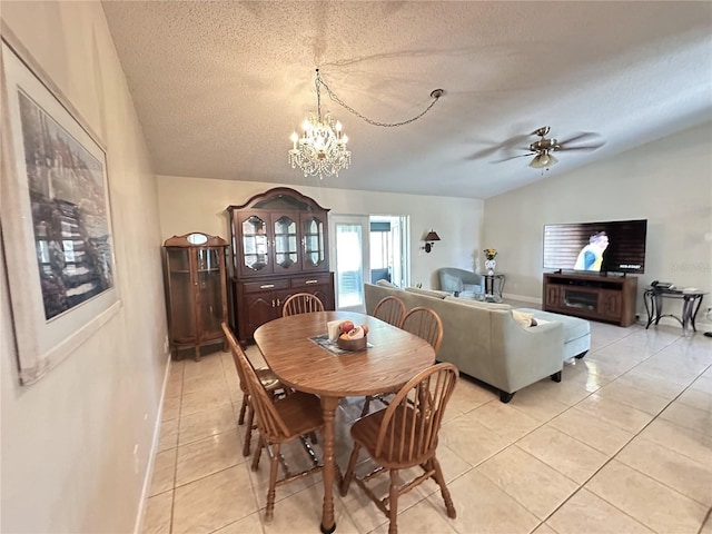 dining area with baseboards, vaulted ceiling, light tile patterned floors, ceiling fan with notable chandelier, and a textured ceiling