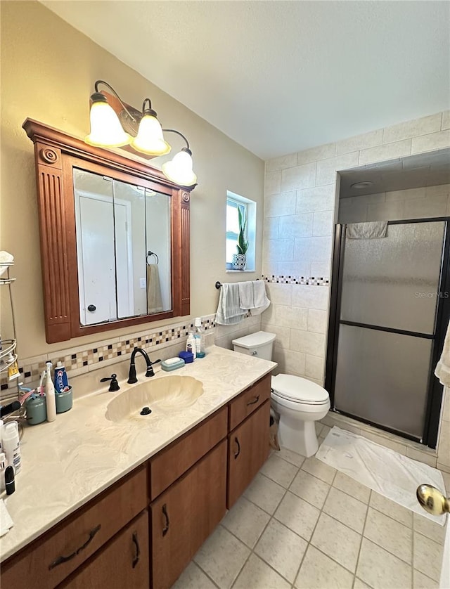 bathroom with vanity, a stall shower, tile patterned floors, toilet, and backsplash