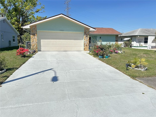 single story home featuring driveway, an attached garage, stucco siding, a front lawn, and stone siding