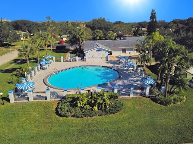 community pool featuring a patio, a yard, and fence