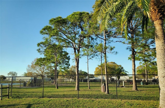 view of home's community with a lawn and fence