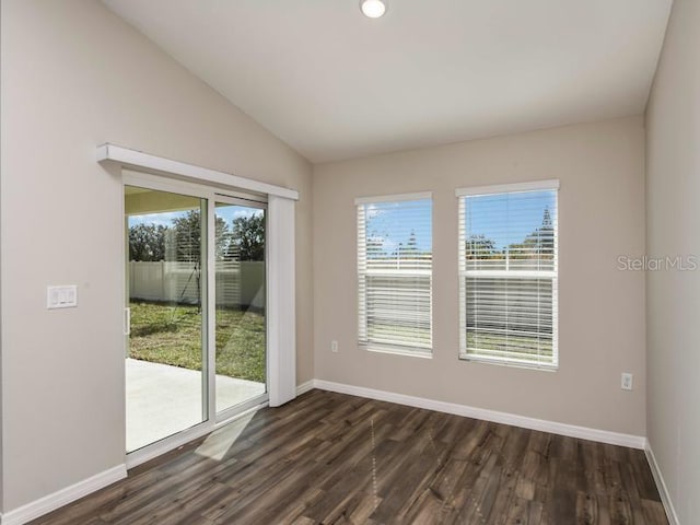 empty room featuring baseboards, dark wood-type flooring, and lofted ceiling