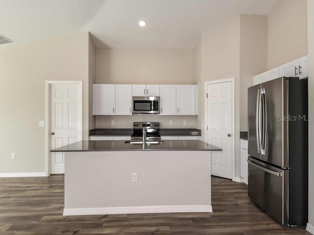 kitchen with a sink, dark countertops, white cabinets, and stainless steel appliances