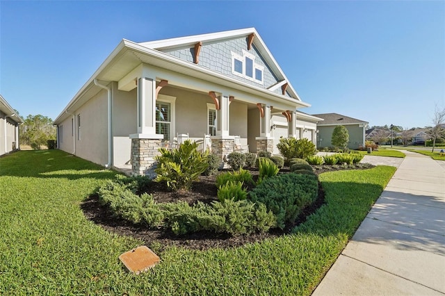 view of front of property with stucco siding, driveway, covered porch, a front yard, and an attached garage