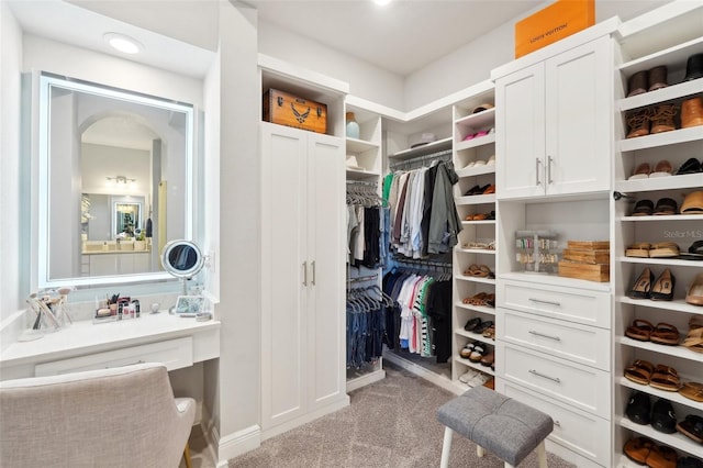 spacious closet featuring carpet floors and arched walkways