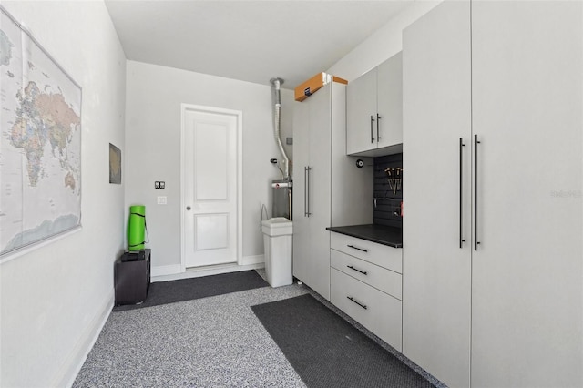 bathroom with speckled floor and baseboards