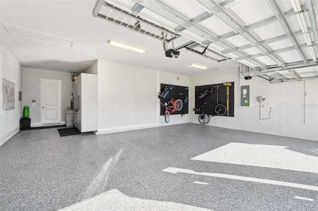 garage featuring concrete block wall, electric panel, and a garage door opener