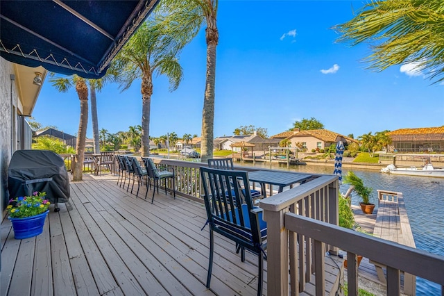 wooden terrace with a residential view, a grill, and a water view