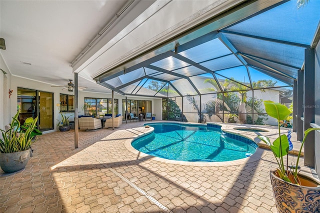 view of swimming pool with a ceiling fan, a pool with connected hot tub, glass enclosure, an outdoor hangout area, and a patio area