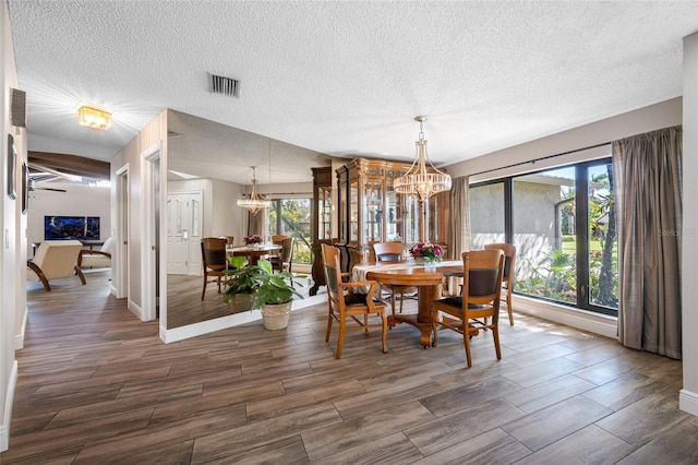 dining space featuring a wealth of natural light, visible vents, an inviting chandelier, and wood tiled floor