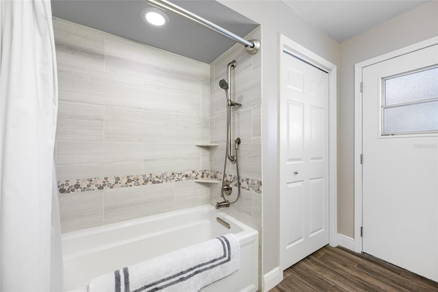 full bath featuring shower / bathtub combination with curtain, baseboards, and wood finished floors