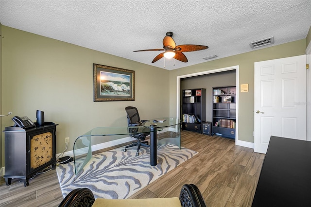 office area featuring wood finished floors, visible vents, and a textured ceiling