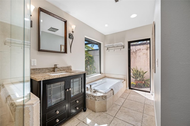 full bath with vanity, a bath, and recessed lighting