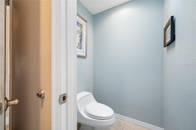 bathroom featuring tile patterned floors, toilet, and baseboards