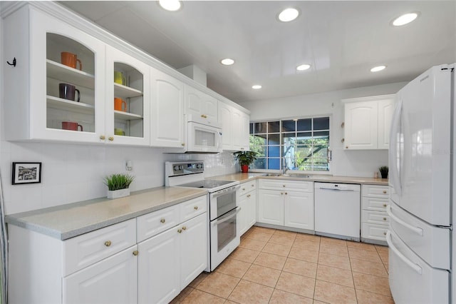 kitchen with light tile patterned floors, recessed lighting, white appliances, and glass insert cabinets