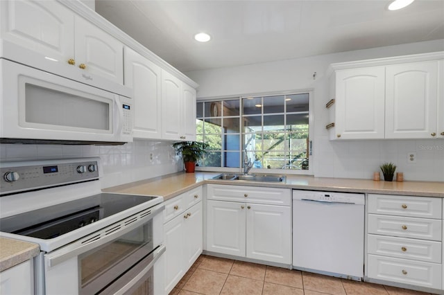 kitchen with tasteful backsplash, white appliances, white cabinetry, and a sink