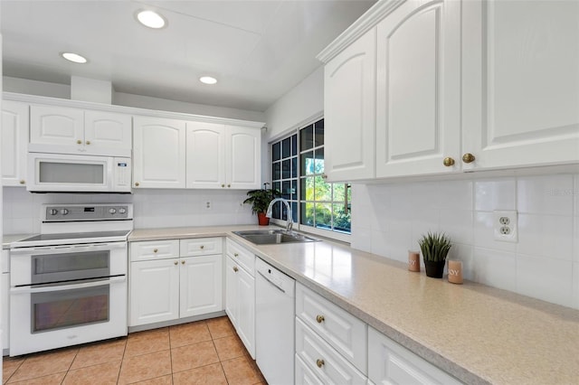 kitchen featuring a sink, white appliances, backsplash, and white cabinets