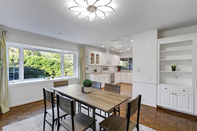 dining space with recessed lighting, a healthy amount of sunlight, an inviting chandelier, and baseboards