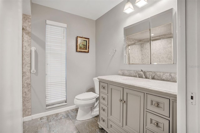 full bath featuring a shower with door, baseboards, toilet, and vanity