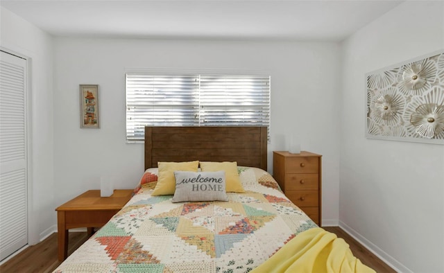 bedroom with a closet, baseboards, and wood finished floors