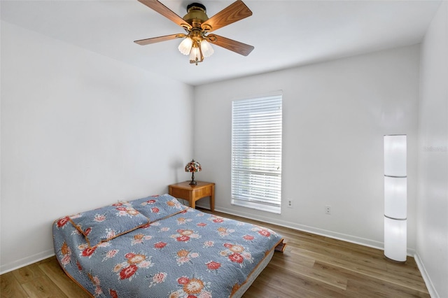 bedroom with baseboards, wood finished floors, and a ceiling fan